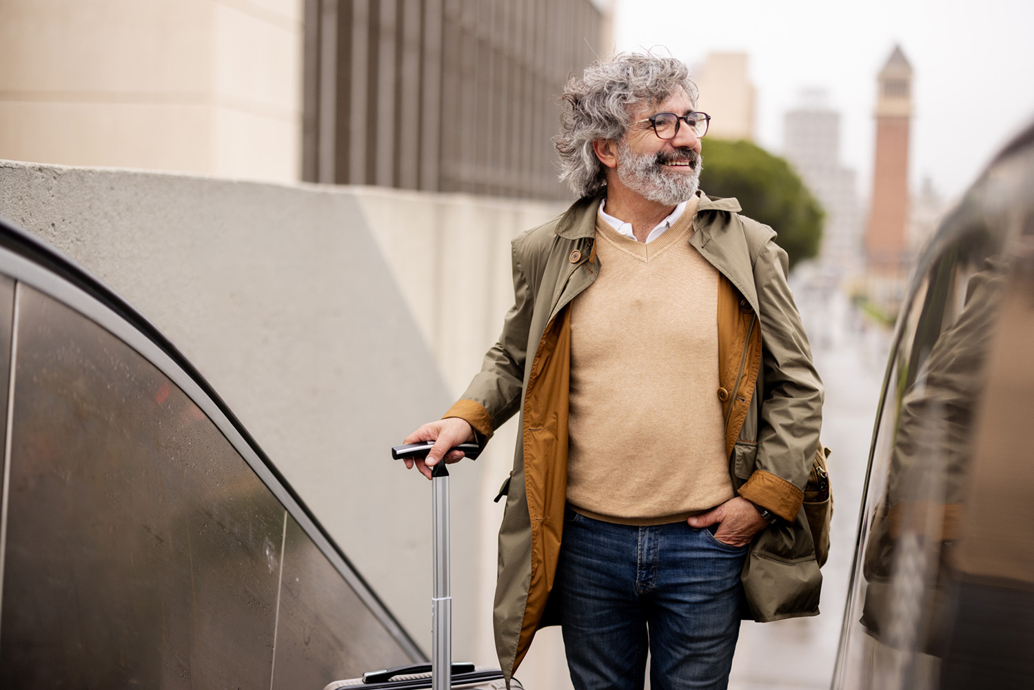 man in glasses walking with luggage