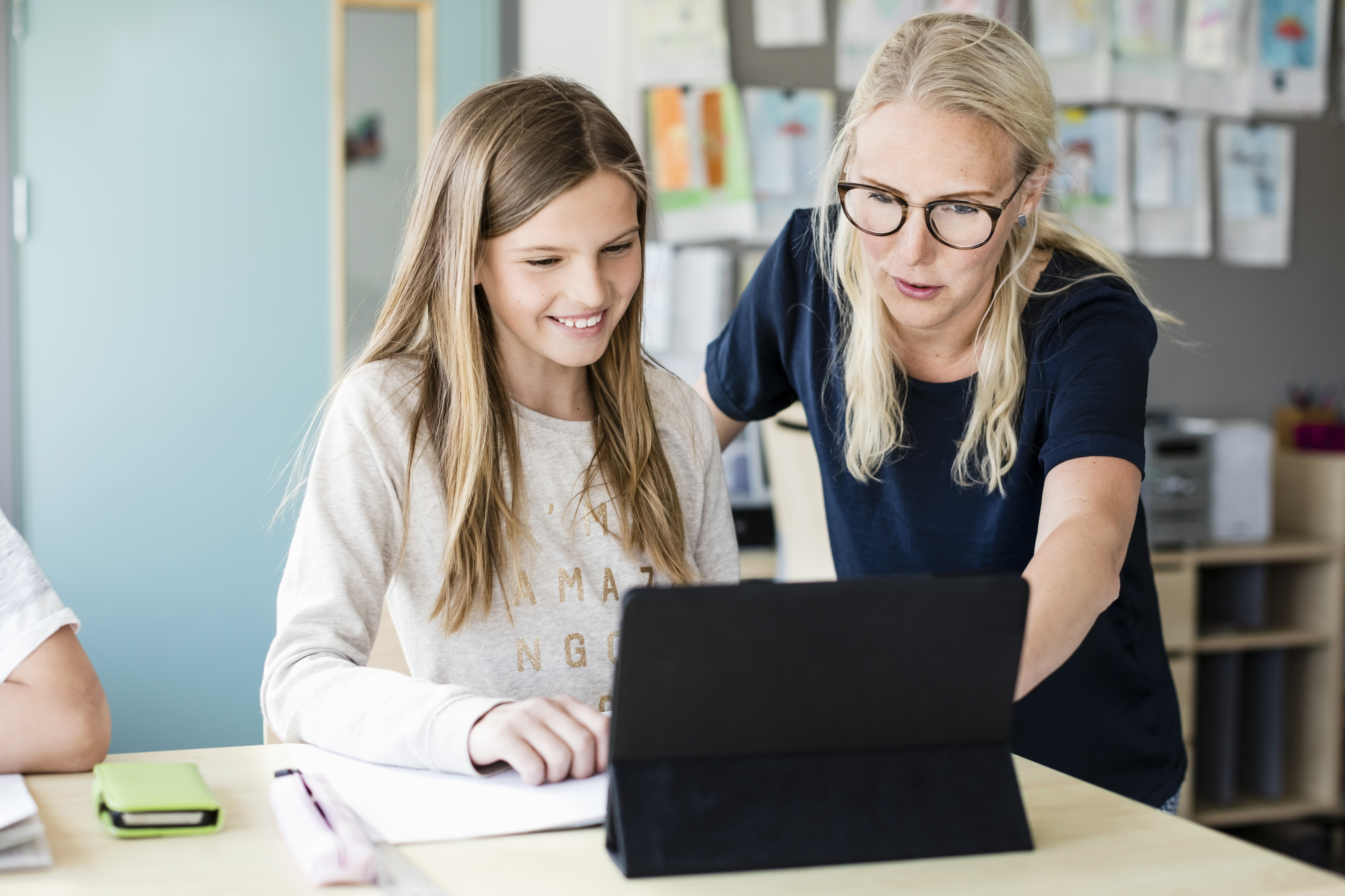 Teacher and student working on a tablet computer