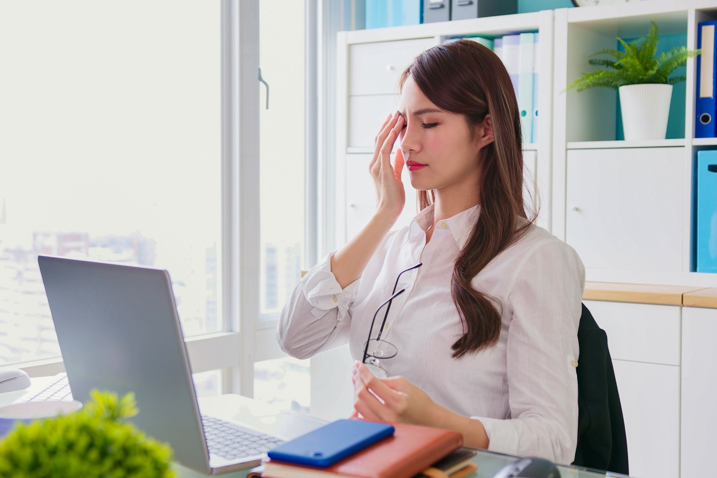 woman holding glasses touching face