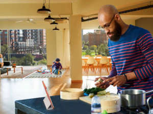 Father cooking while children play